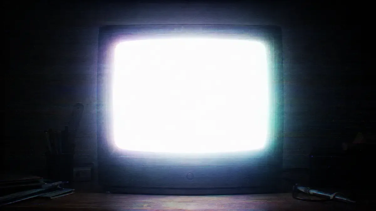 Monitor CRT con el brillo completamente quemado y halo blanco desbordando la pantalla